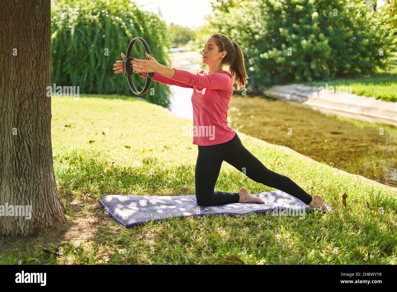 Full body side view of focused sportsWoman doing exercise with fitness ...