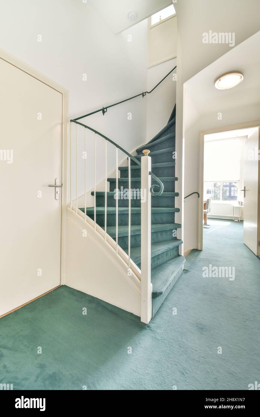 Corridor with stairway and metal railing placed at wall in spacious ...