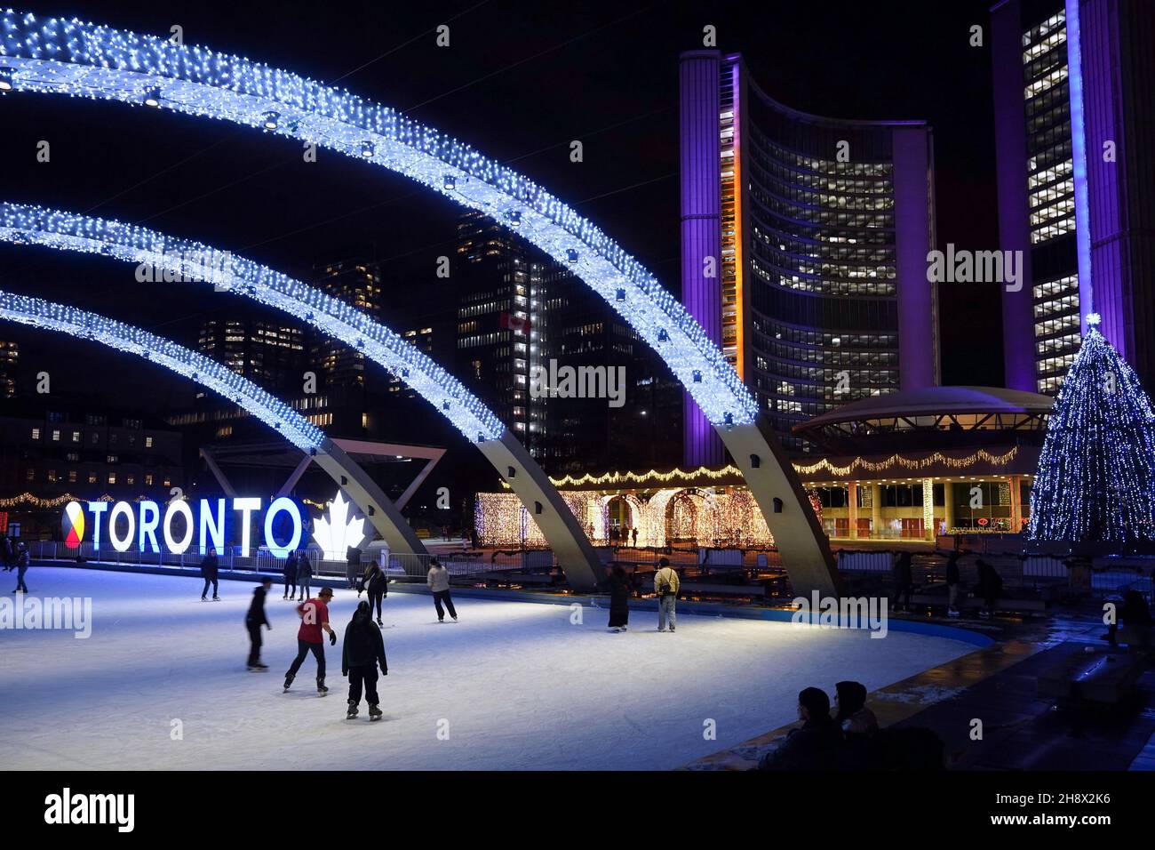 Toronto, Canada - November 30, 2021:  Toronto City Hall square is lit up with bright lights in alternating colors for the Christmas season. Stock Photo