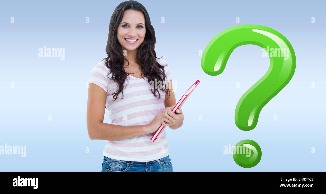 Portrait of smiling young woman holding book by green question mark over blue background Stock Photo
