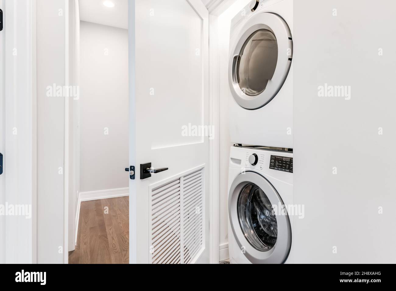 White Stackable Washer and Dryer in Closet Stock Photo