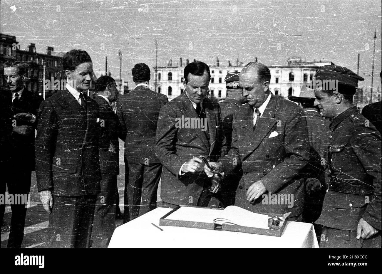 Warszawa, Plac Zwyciêstwa, 1946. Z oficjaln¹ wizyt¹ przyby³a do Polski delegacja Organizacji Narodów Zjednoczonych do Spraw Pomocy i Odbudowy (UNRRA - United Nations Relief and Rehabilitation Administration) z jej dyrektorem generalnyn - Fiorello LaGuardi¹, który osobiœcie chcia³ siê zapoznaæ z rozmiarem strat poniesionych przez nasz¹ ojczyznê. UNRRA zosta³a utworzona przez Narody Zjednoczone w 1943 w celu udzielenia pomocy krajom wyzwolonym w Europie oraz Azji po zakoñczeniu II wojny œwiatowej. Nz. m.in.: delegacja UNNRY wpisuje siê do ksiêgi pami¹tkowej przy Grobie Nieznanego ¯o³nierza. pp Stock Photo