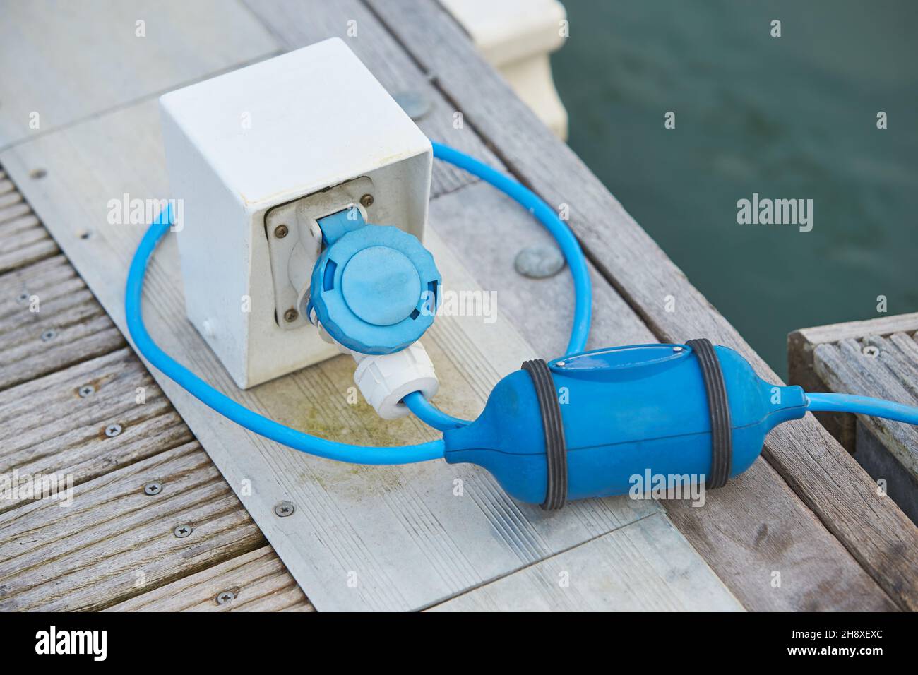 Electrical power socket bollard on pier. Charging station for boats in
