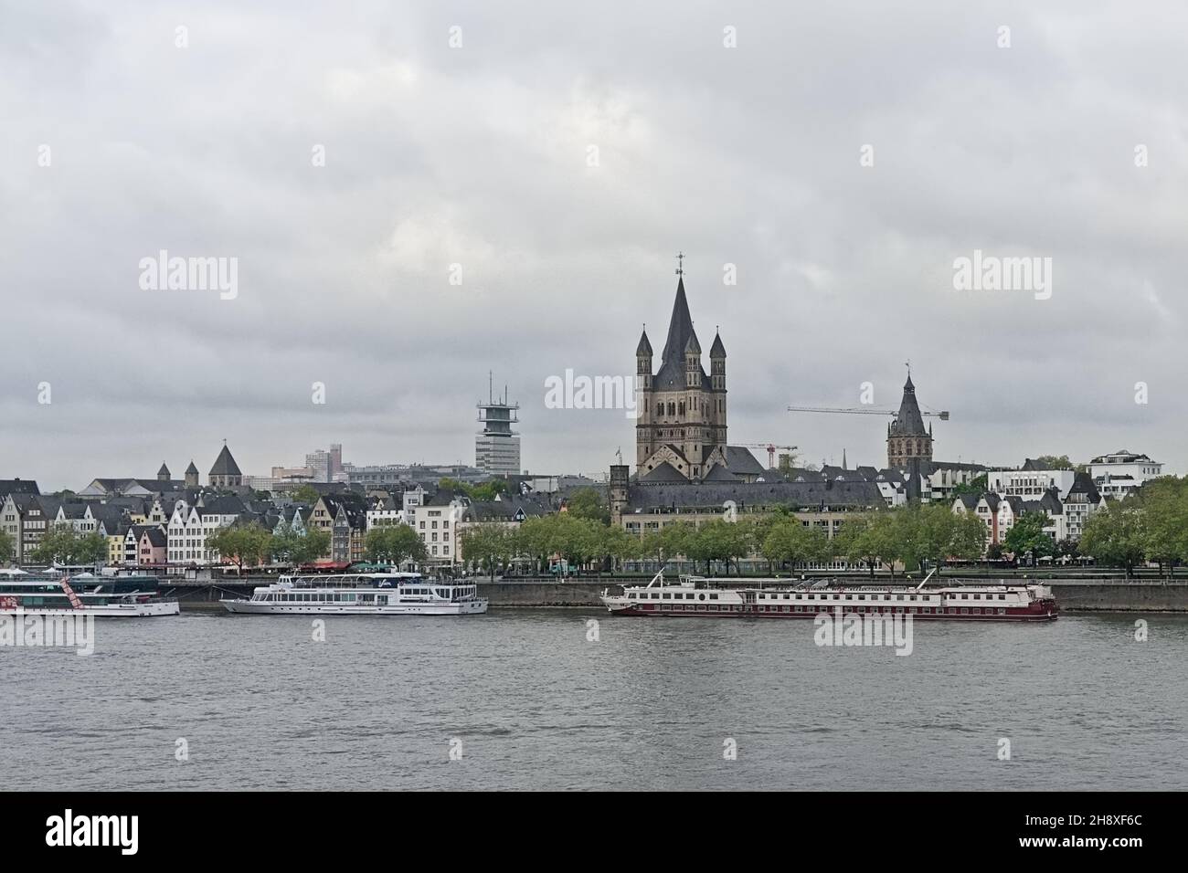 River rhine with tourist boats and traditional houses and Great Saint martin church in Cologne,Germany Stock Photo