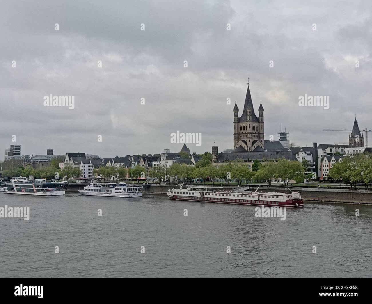 River rhine with tourist boats and traditional houses and Great Saint martin church in Cologne,Germany Stock Photo