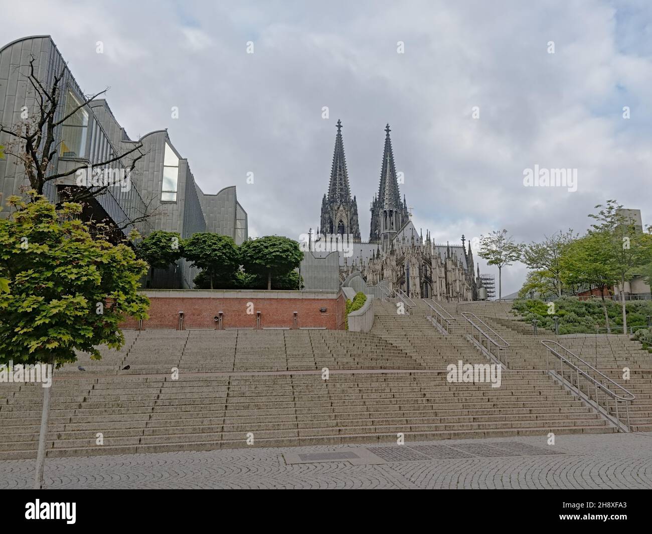 Stairs up to Cologne cathedral along the modern art museum Ludwig on a cloudy day in Cologne, Ge Stock Photo
