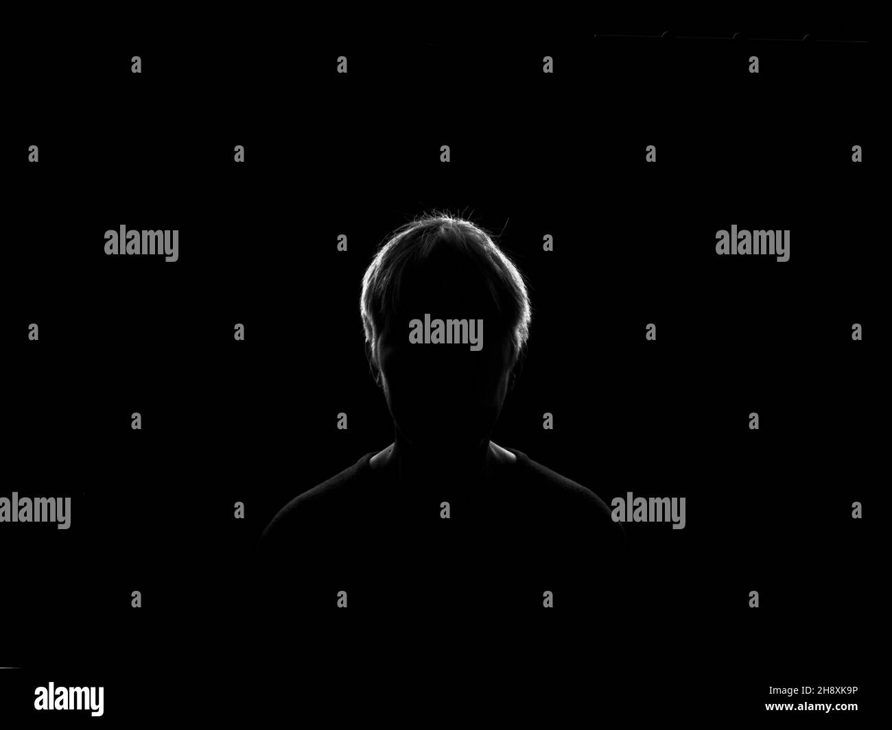 A silhouette of a woman on a black background with rim light to create