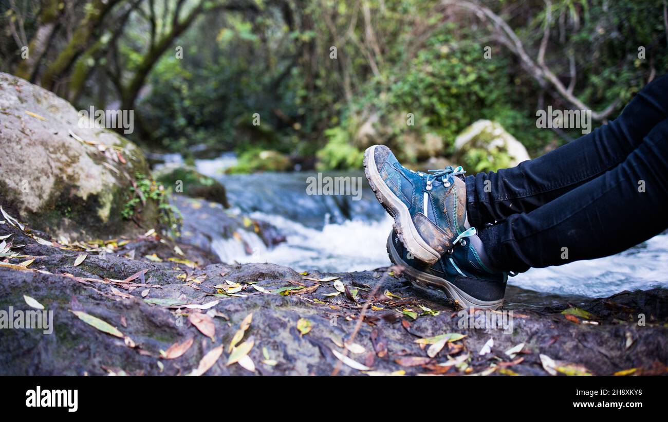 Detail of the boots of a woman hiking along the bank of a river Stock ...