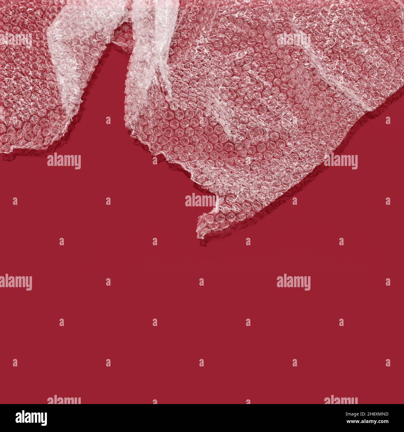 Bubble wrap with shadow against red background Stock Photo