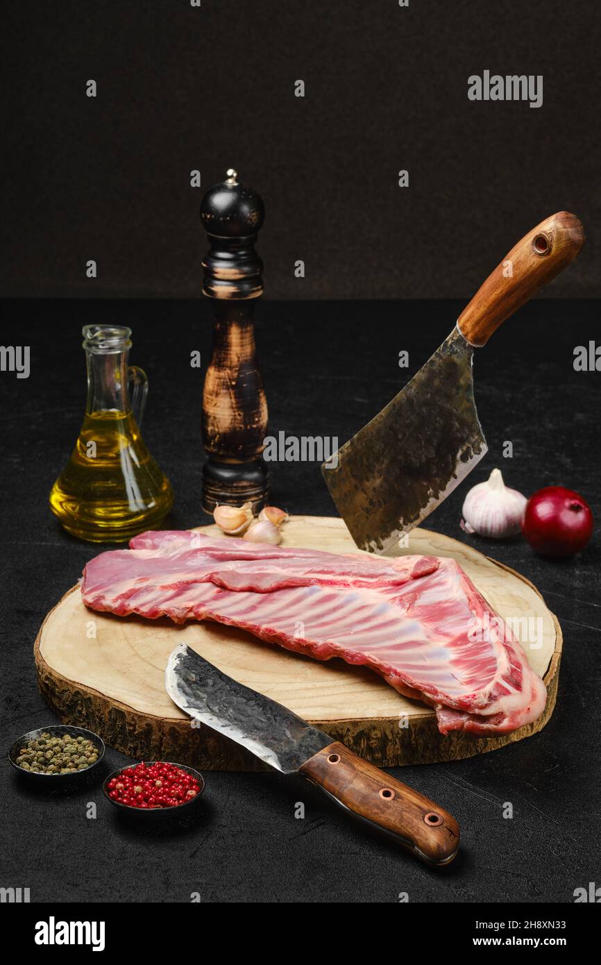 Raw fresh lamb ribs, uncut with spices and herbs on kitchen table Stock Photo