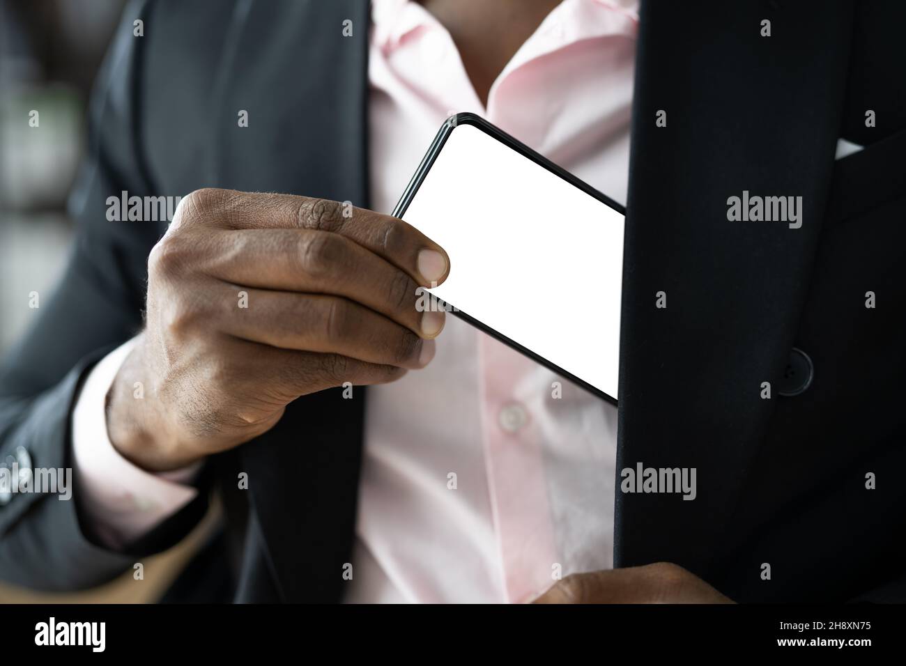African Man Holding Cellphone Or Mobile Phone Stock Photo