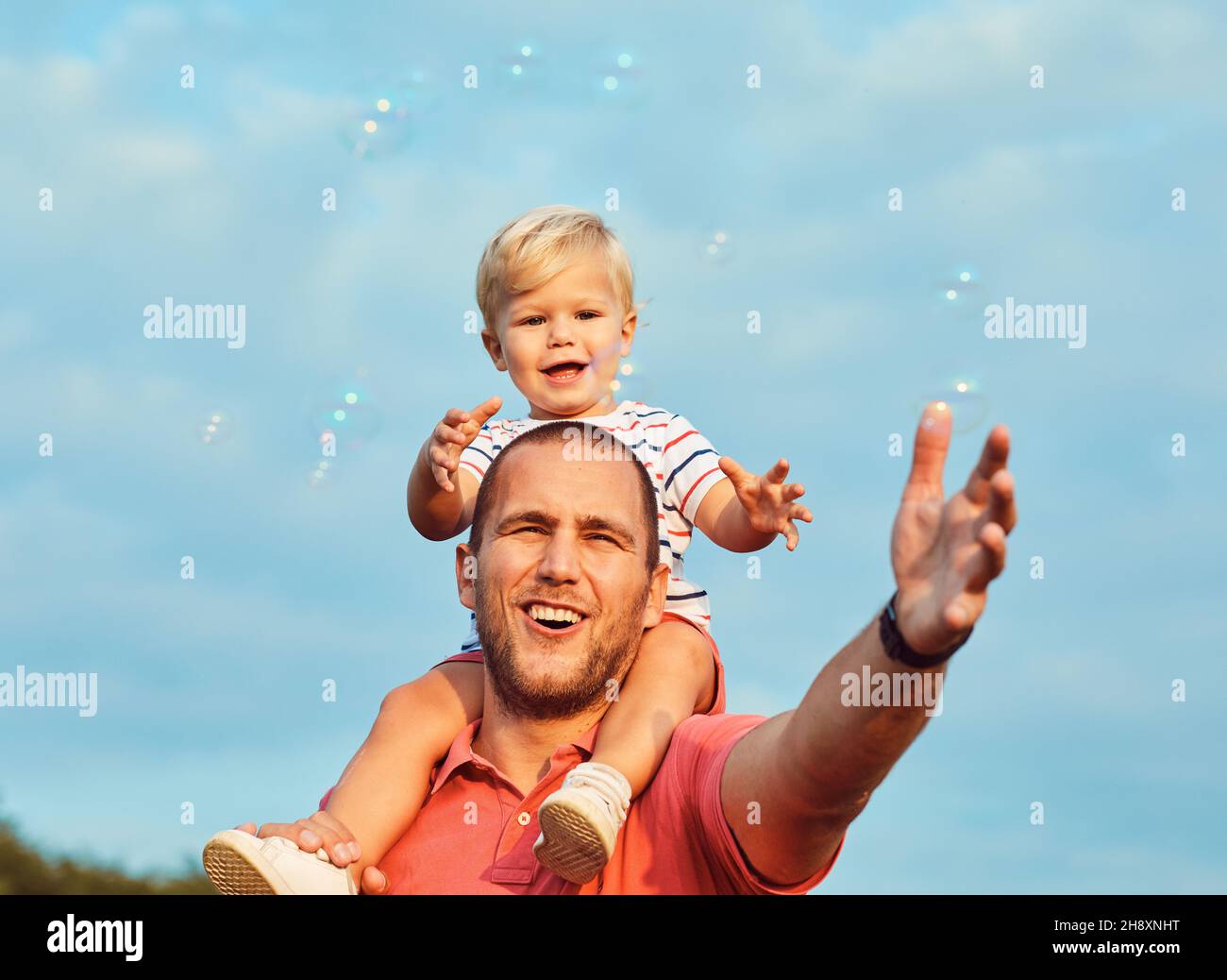child son father family happy playing kid childhood dad love fun smiling little man soap bubble summer love Stock Photo