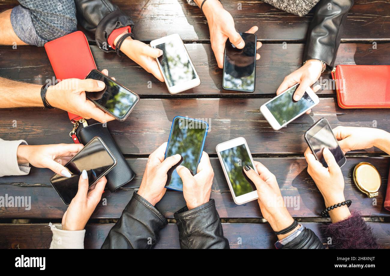 People group having addicted fun together using smartphones - Detail of hands sharing content on social network with mobile smart phones Stock Photo