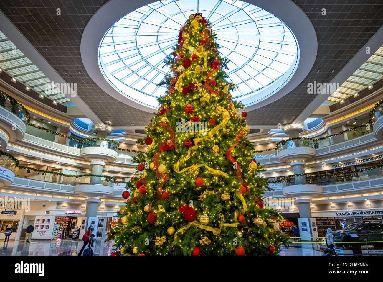 A large decorated Christmas tree greets holiday travelers in the atrium of Hartsfield-Jackson Atlanta International Airport in Atlanta, Georgia. (USA) Stock Photo