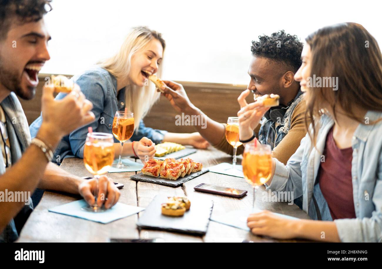 Friends eating and drinking spritz at fashion cocktail bar restaurant