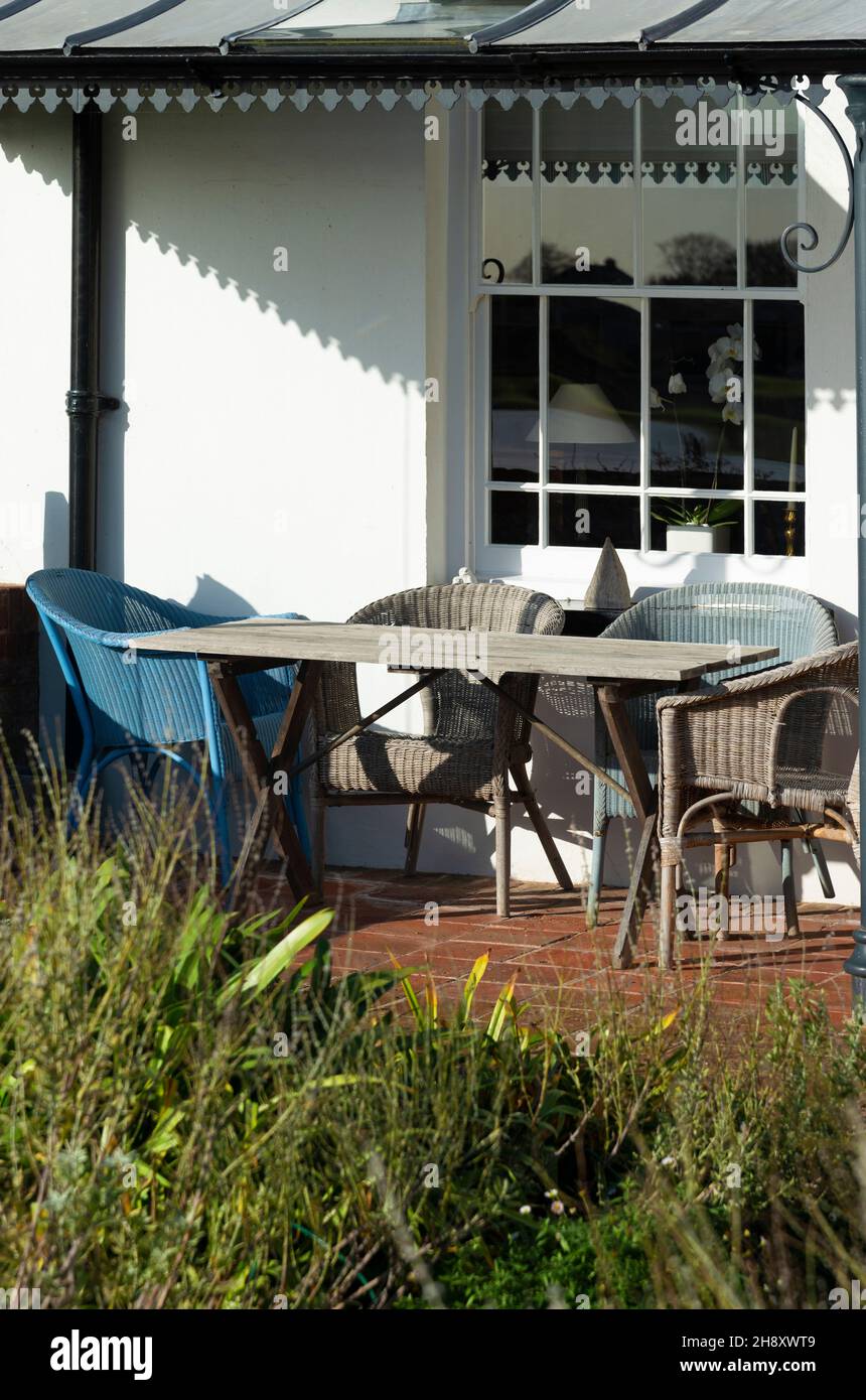 Lloyd Loom chairs on terrace of house in the picturesque seaside village of Bosham in Chichester Harbour,  near Chichester, West Sussex, England,UK Stock Photo