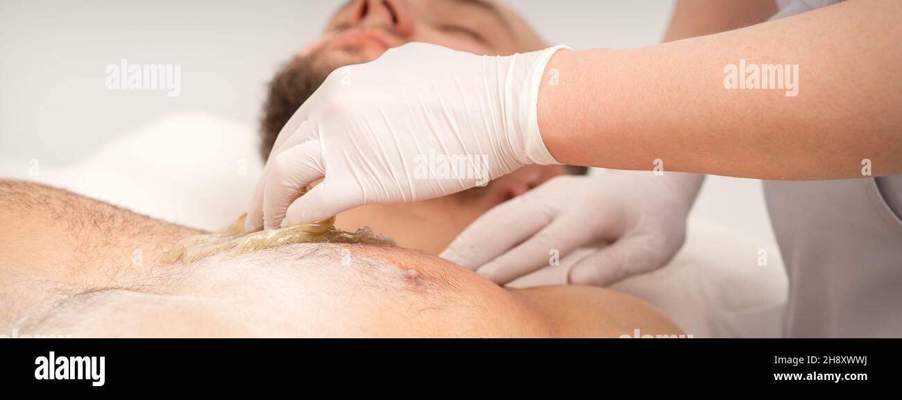 Epilation chest of a young male with the liquid wax paste in a beauty salon Stock Photo