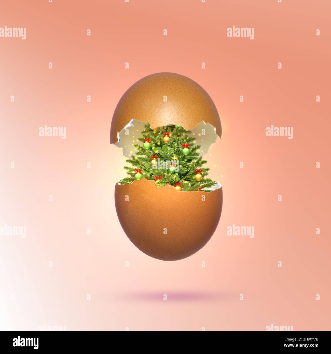 Egg shell broken into halves with a Christmas tree inside. Egg surprise concept. Stock Photo