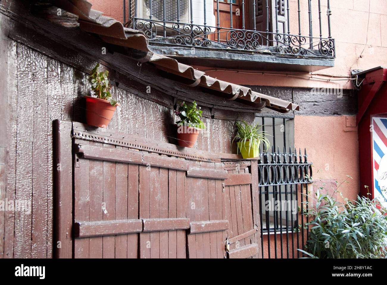 Window with closed wooden shutters on which hang three flowerpots. Vertical photography. Copy space. Stock Photo