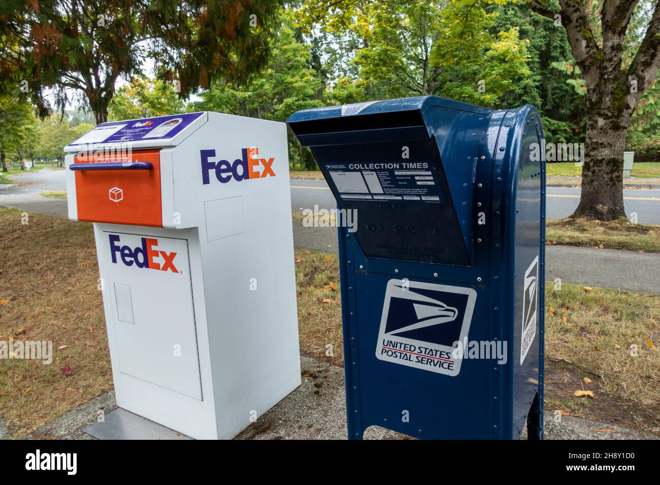 Kirkland, WA USA - circa September 2021: Angled view of a FedEx package and letter deposit station next to a blue USPS deposit box in downtown Kirklan Stock Photo