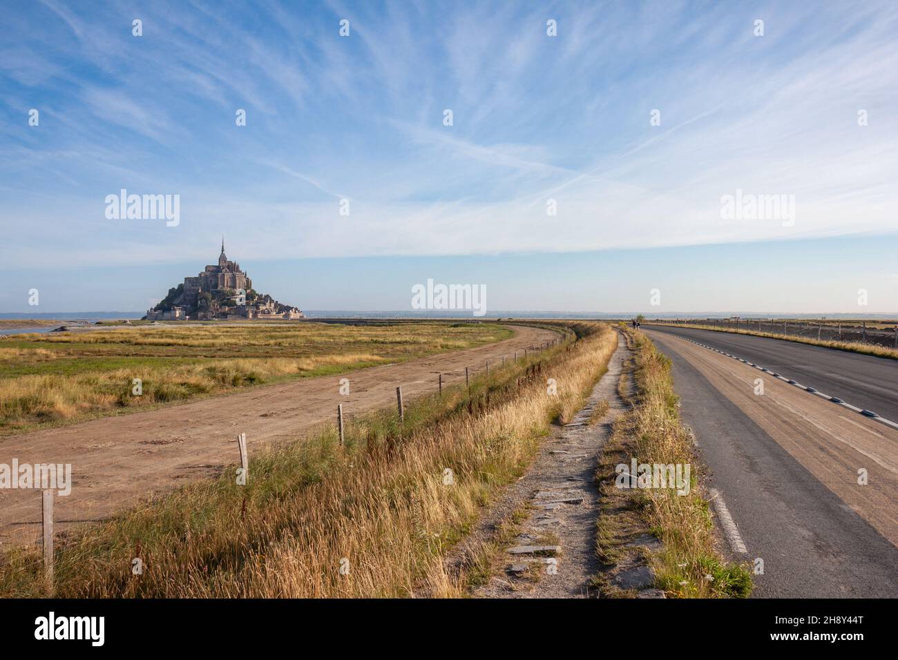 view towards Mont Saint-Michel looking over the access road and some grassland, Normandy France Stock Photo