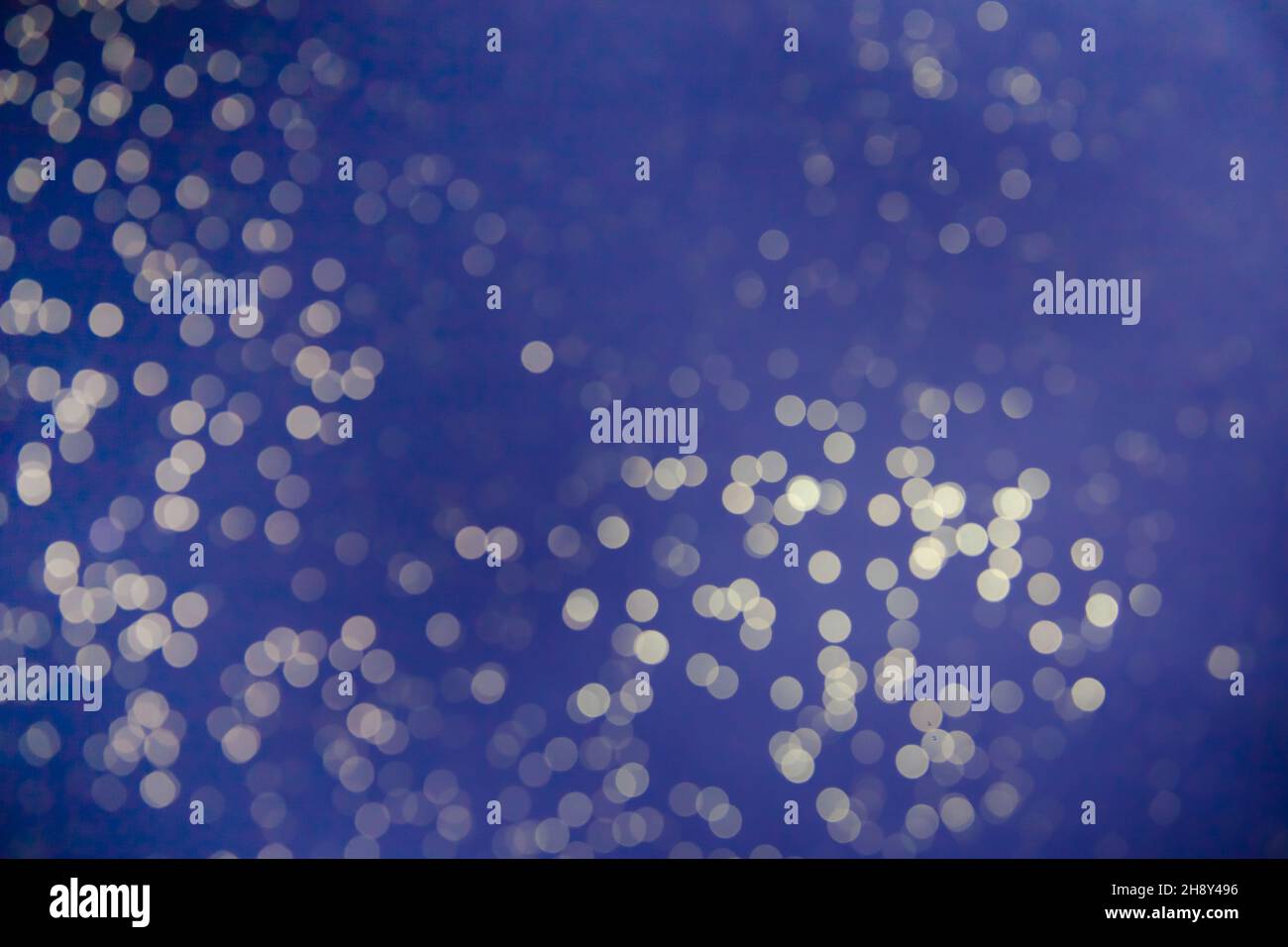 Lights on blue background. White bokeh on a blue background. Abstract with lights. Stock Photo