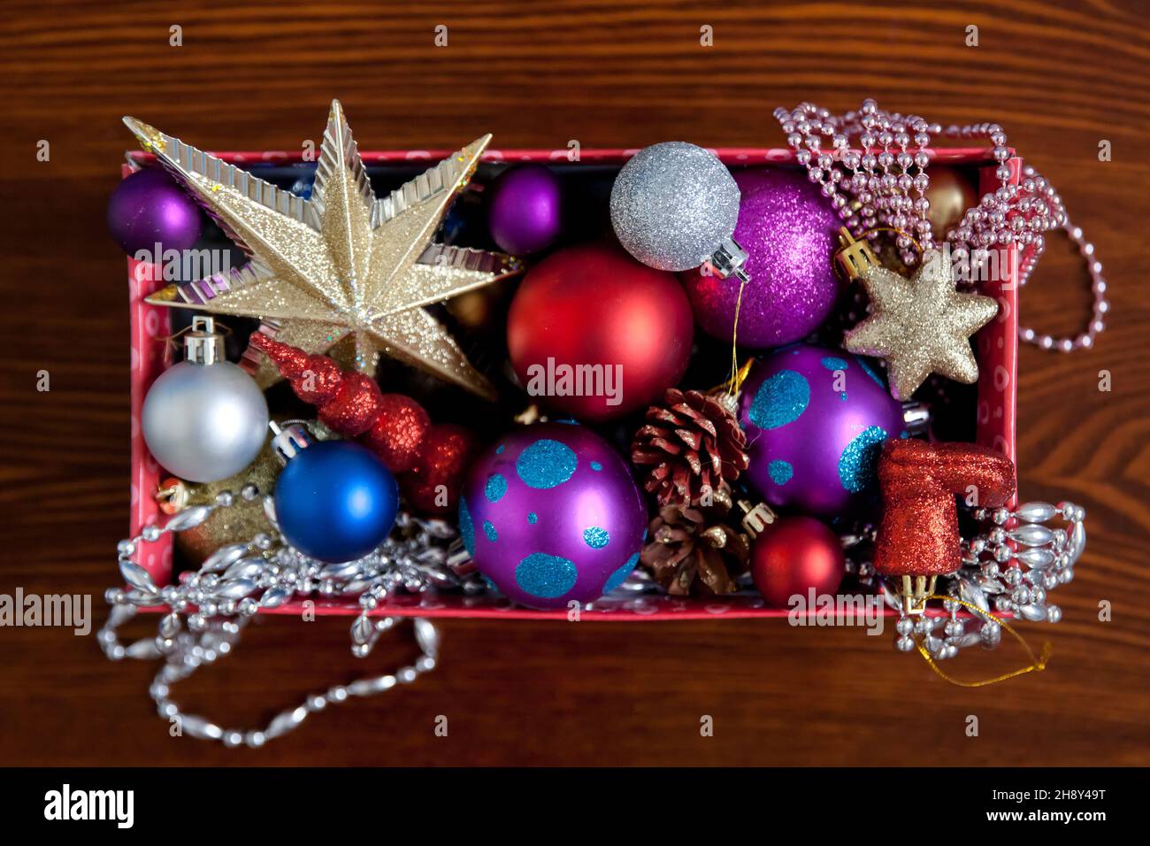Christmas Decorations packed away in a cardboard box. box with christmas decorations. Christmas decorations on the table. Stock Photo