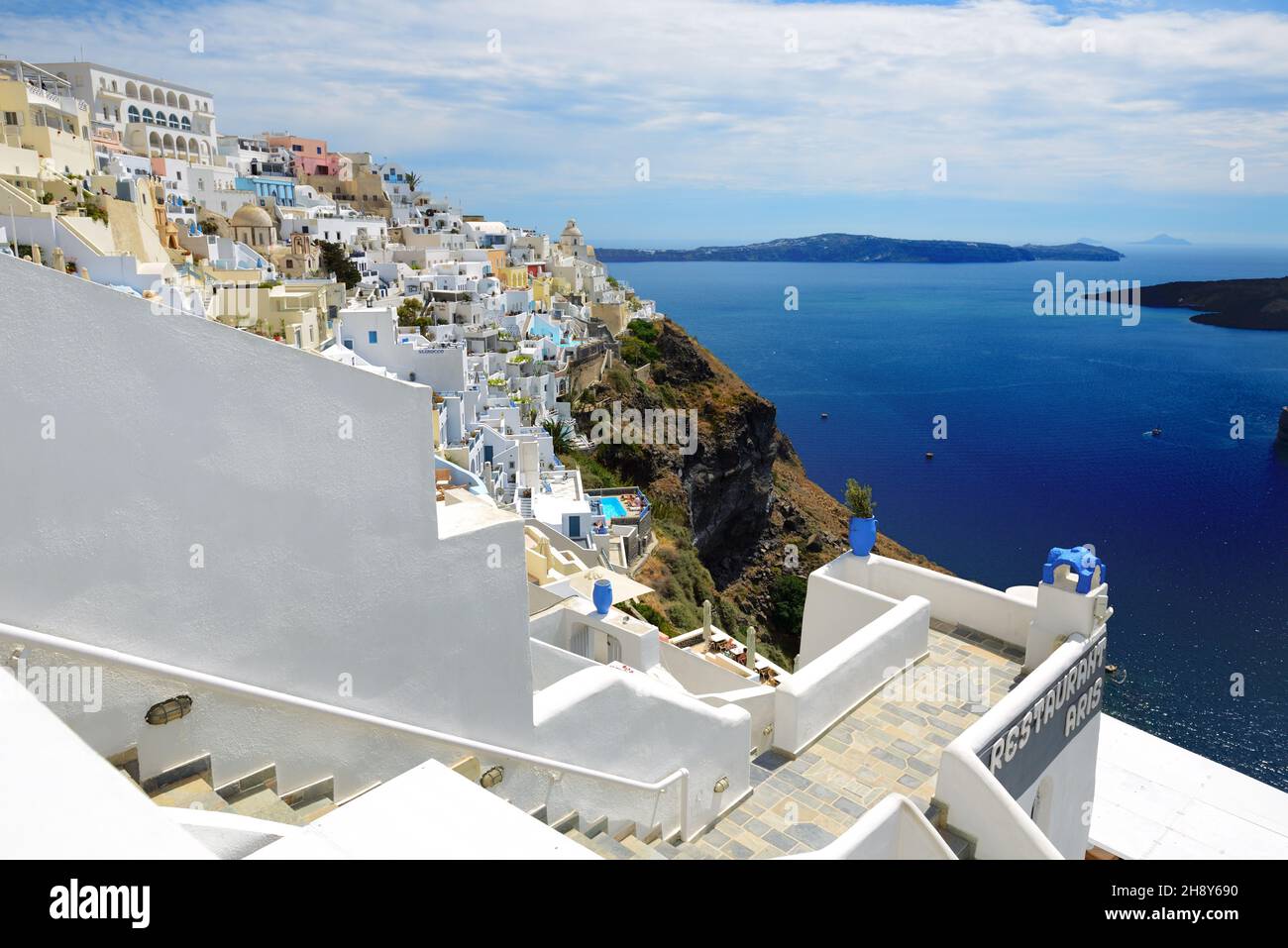 FIRA, GREECE - MAY 17: The view on Fira town and tourists enjoying their vacation on May 17, 2014 in Fira, Greece. Up to 16 mln tourists is expected t Stock Photo