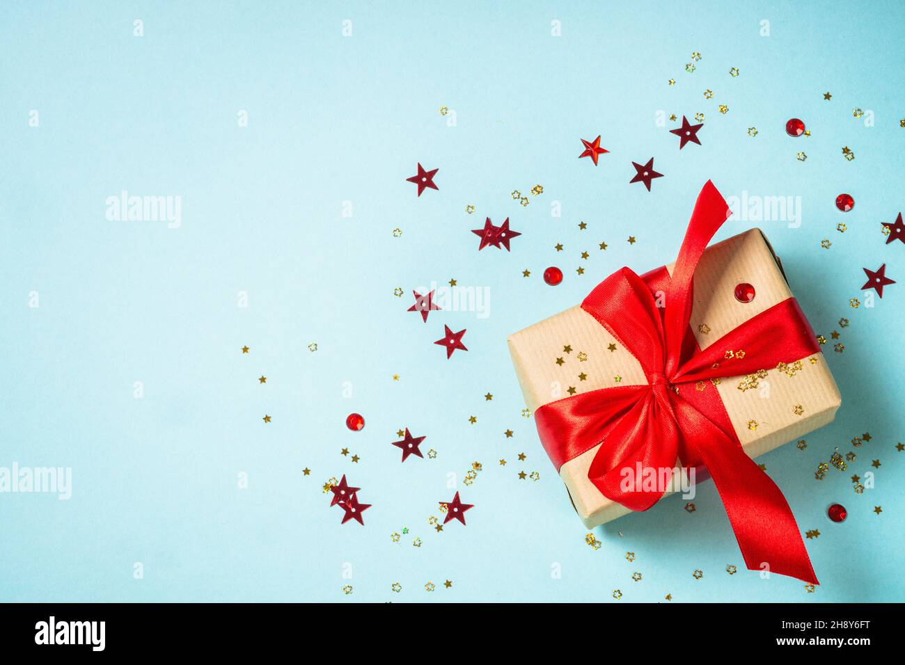 Christmas present box with red ribbon at blue. Stock Photo