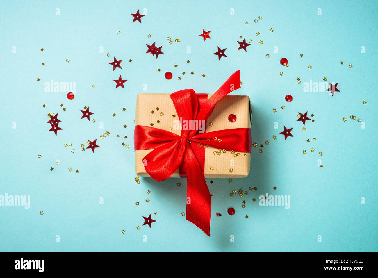 Christmas present box with red ribbon at blue. Stock Photo