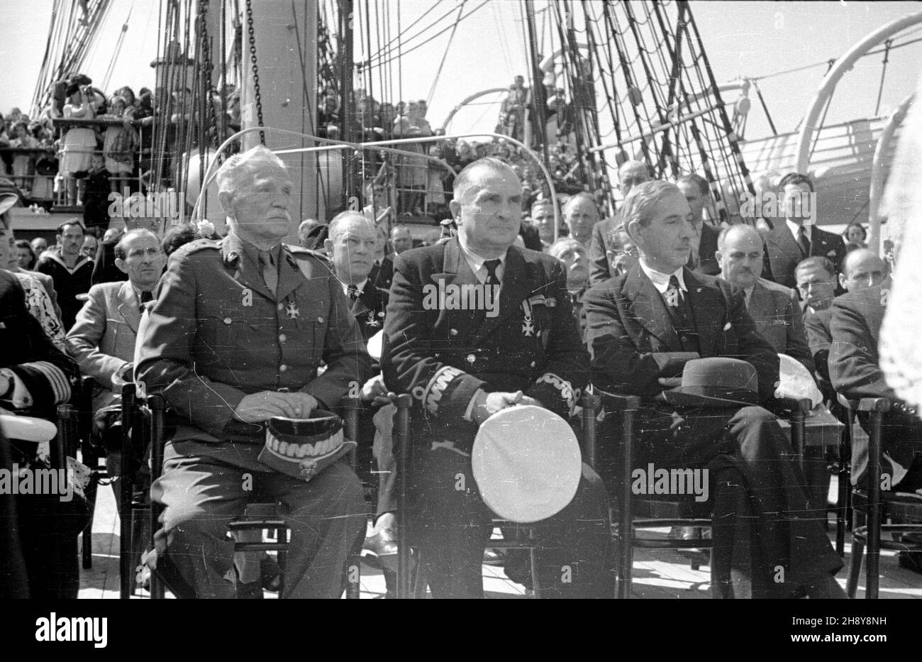 Gdynia, 1946-07-20. Msza œwiêta podczas uroczystoœci po¿egnania Daru Pomorza, statku szkoleniowego polskiej marynarki handlowej, przed jego pierwszym powojennym rejsem do Marsylii. Nz. siedz¹ z przodu: kontradmira³ Adam Mohuczy (C) i pe³nomocnik rz¹du do spraw wybrze¿a Eugeniusz Kwiatkowski (P). ps/ms  PAP/Miko³aj Sprudin      Gdynia, July 20, 1946. The field mass during ceremonies aboard Dar Pomorza Polish Merchant Navy training ship, before its first post-war trip to Marseille, France. Pictured in the foreground sitting: Rear Admiral Adam Mohuczy (centre) and Government Commissioner for the Stock Photo