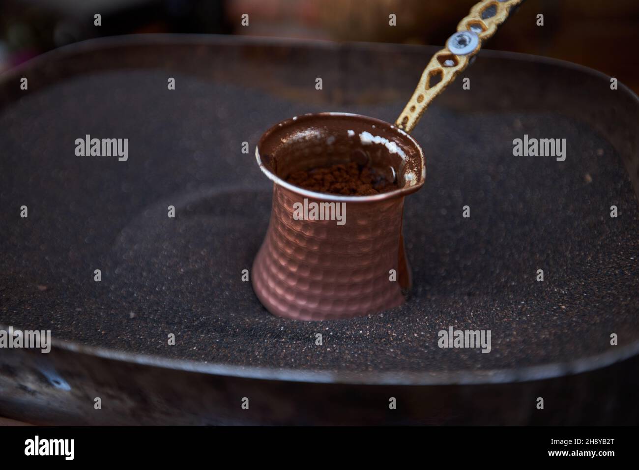 Aromatic coffee brewed in hot sand turkish coffee brewing in cezve