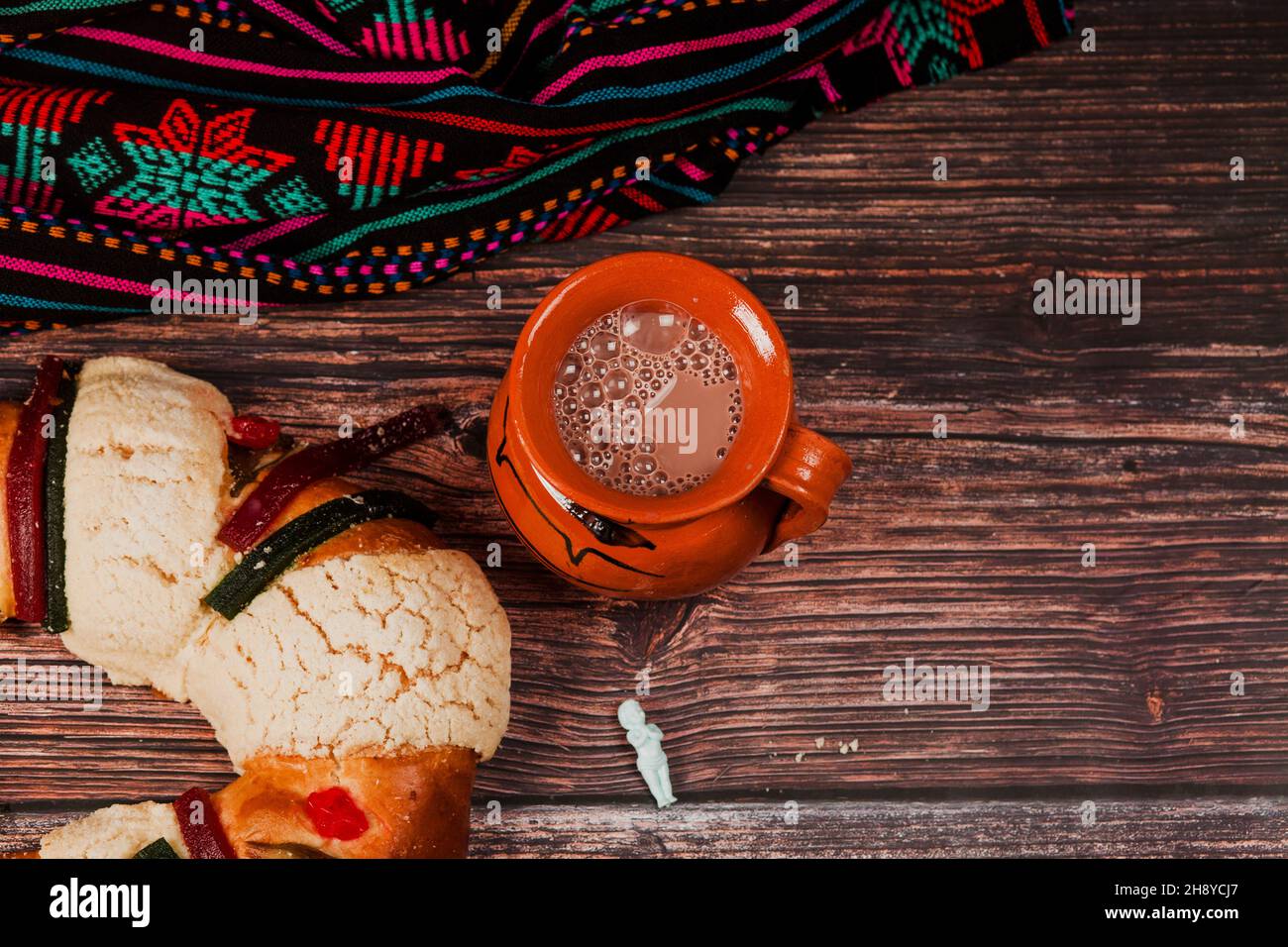 Rosca de reyes or Epiphany cake and clay mug of mexican hot chocolate on wooden table in Mexico Latin America Stock Photo