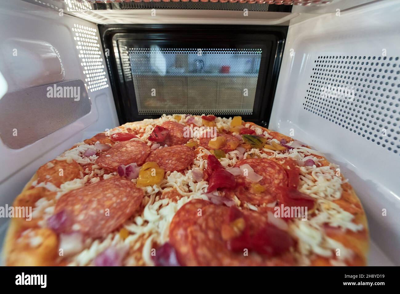 Heating pizza in a microwave oven Stock Photo