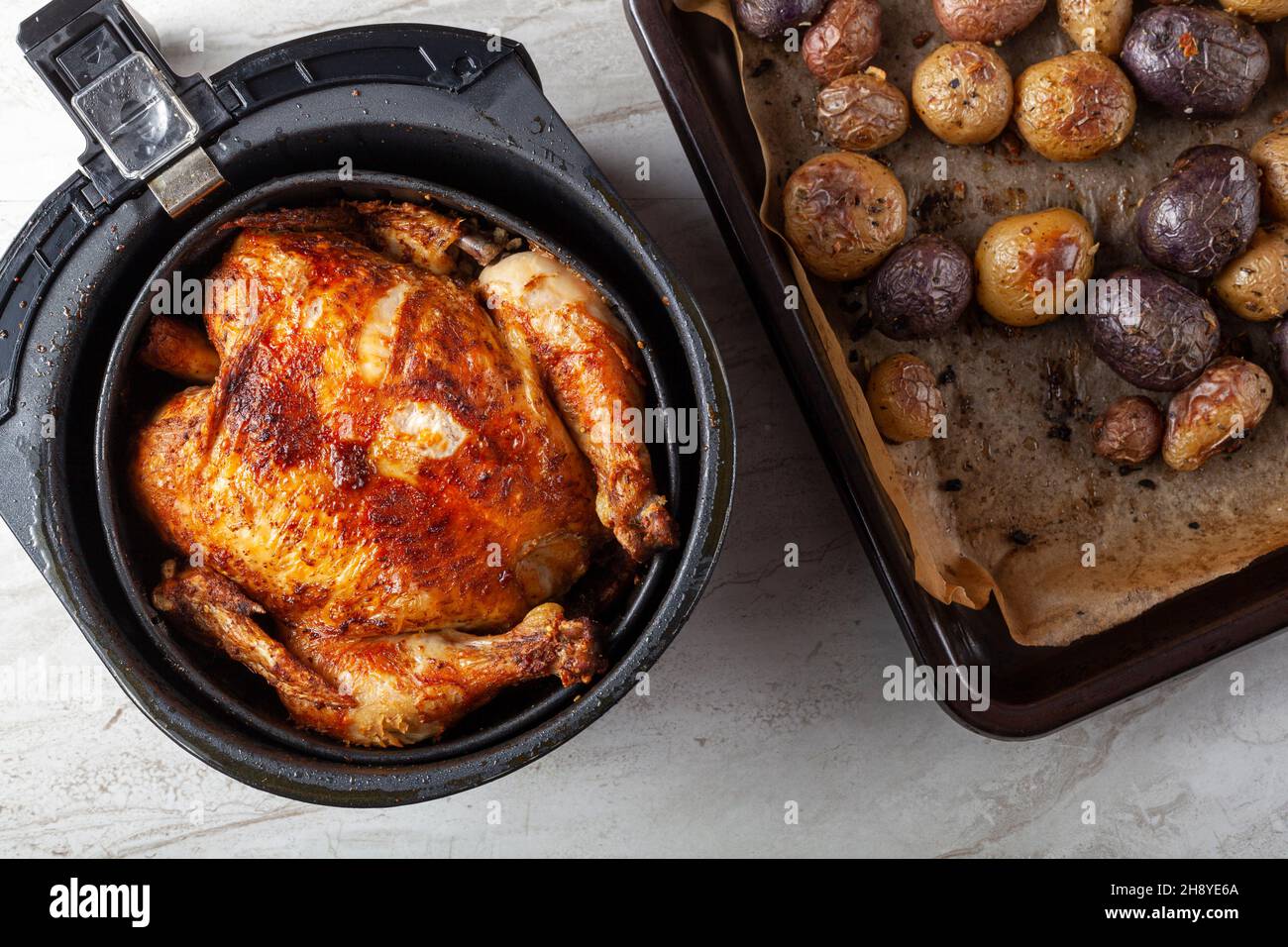 A whole chicken cooked inside an air frier concept. A healthy nutritious homemade alternative to deep fried store bought meat. Served inside the fryer Stock Photo