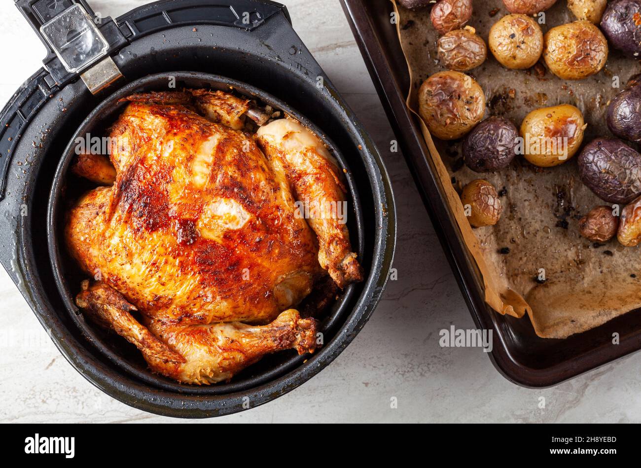 A whole chicken cooked inside an air frier concept. A healthy nutritious homemade alternative to deep fried store bought meat. Served inside the fryer Stock Photo