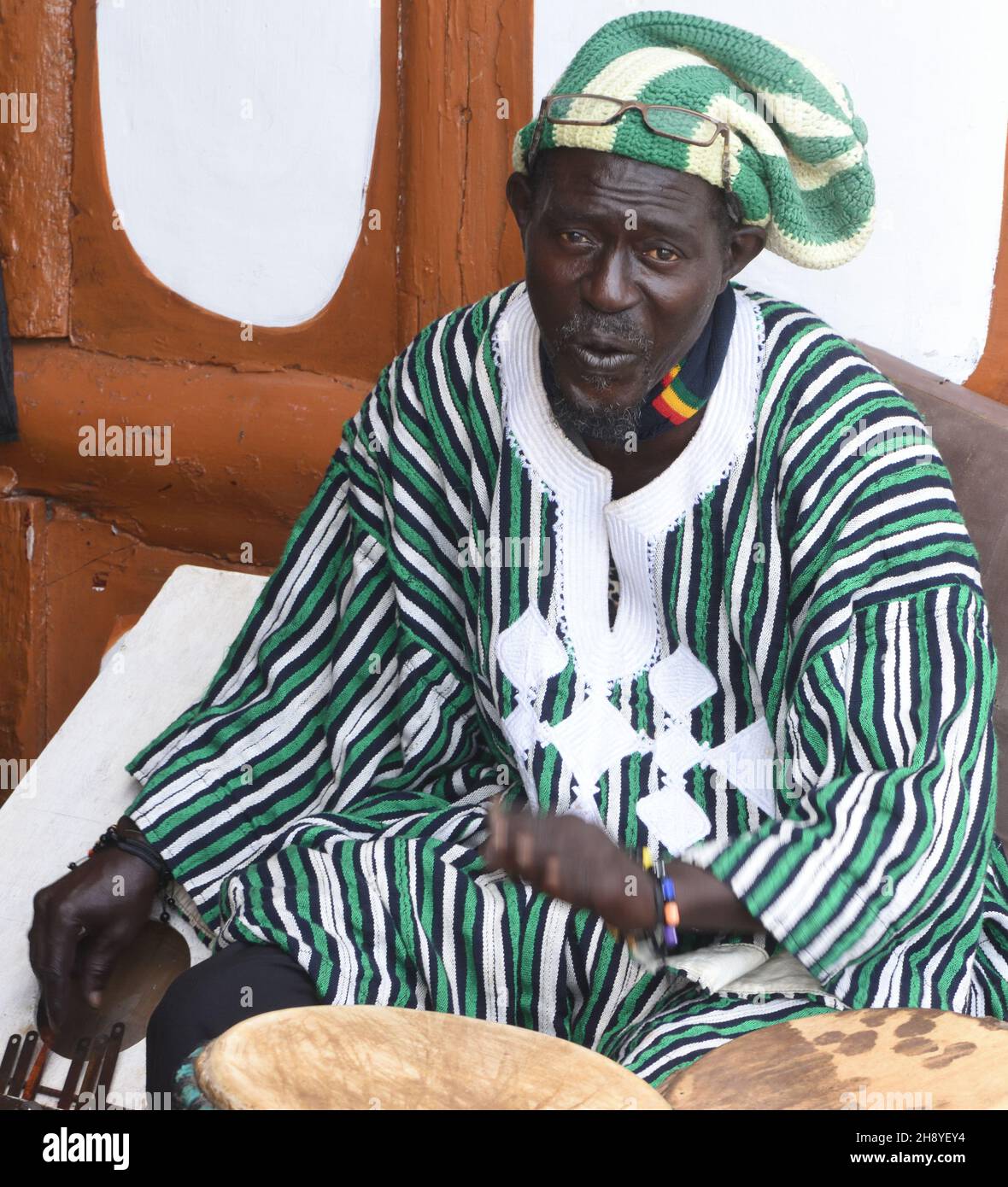 A musician plays drums, djembe or jembe and’ with his right hand, a thumb piano, kalimba. Lamin Lodge, Lamin, The Republic of the Gambia. Stock Photo