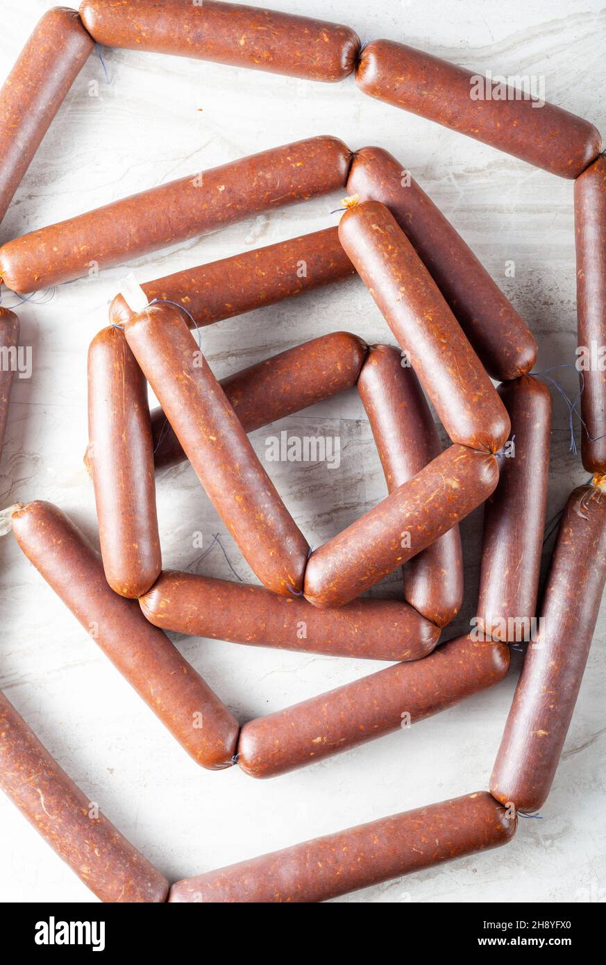 Closeup isolated image of strings of homemade sucuk or sausage stuffed in casing and made into strings before drying. Processed red meat consumption c Stock Photo