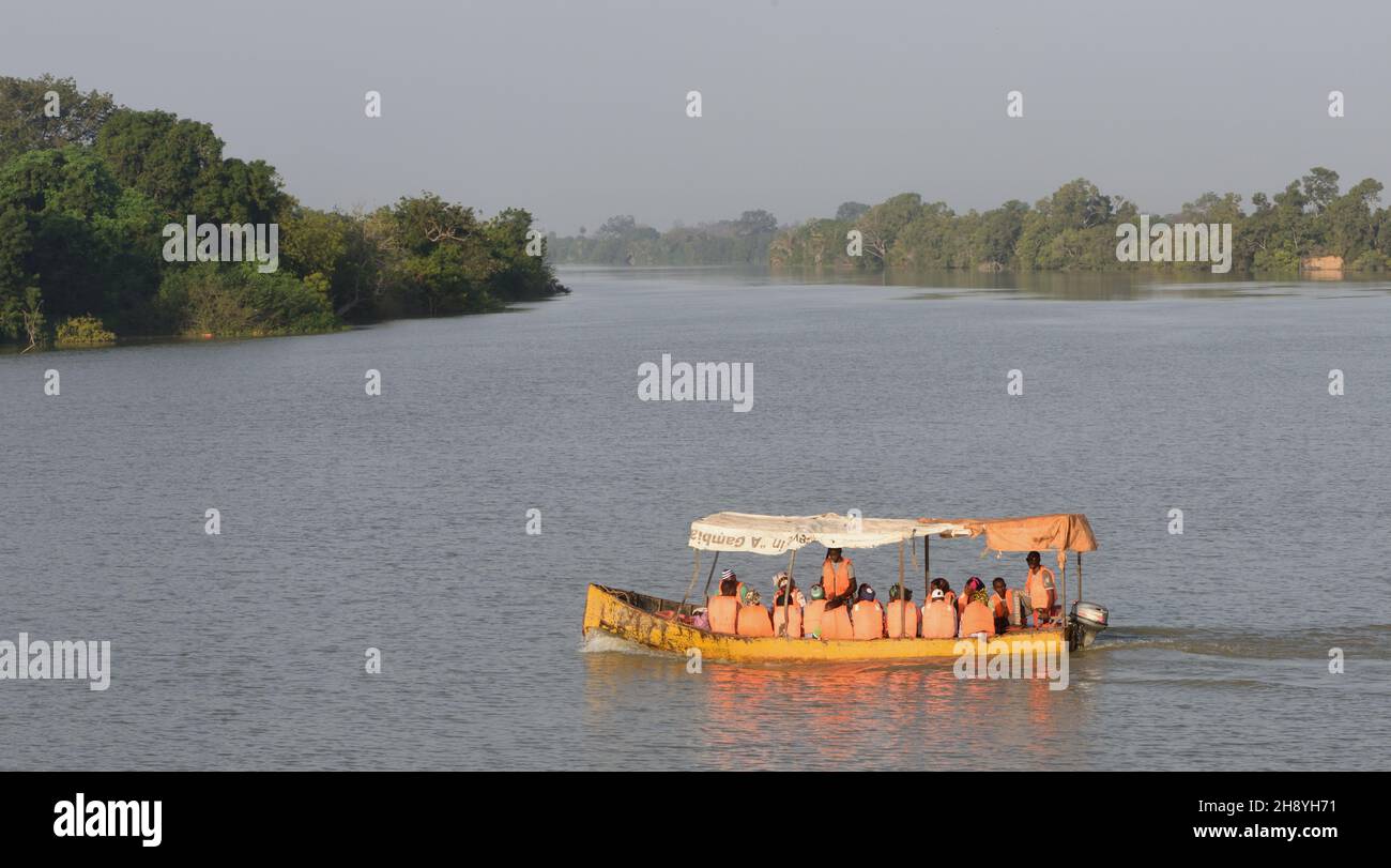 Small passenger ferries carry life-jacketed passengers across the Gambia River to and from Janjanbureh. . Janjanbureh, The Republic of the Gambia. Stock Photo