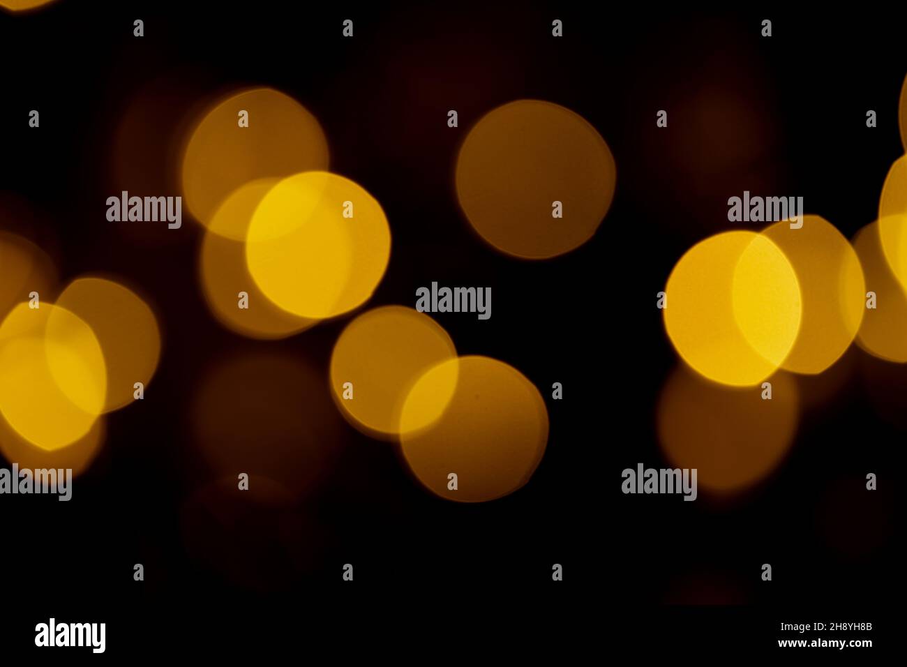 Abstract yellow bokeh texture on black background. Stock Photo