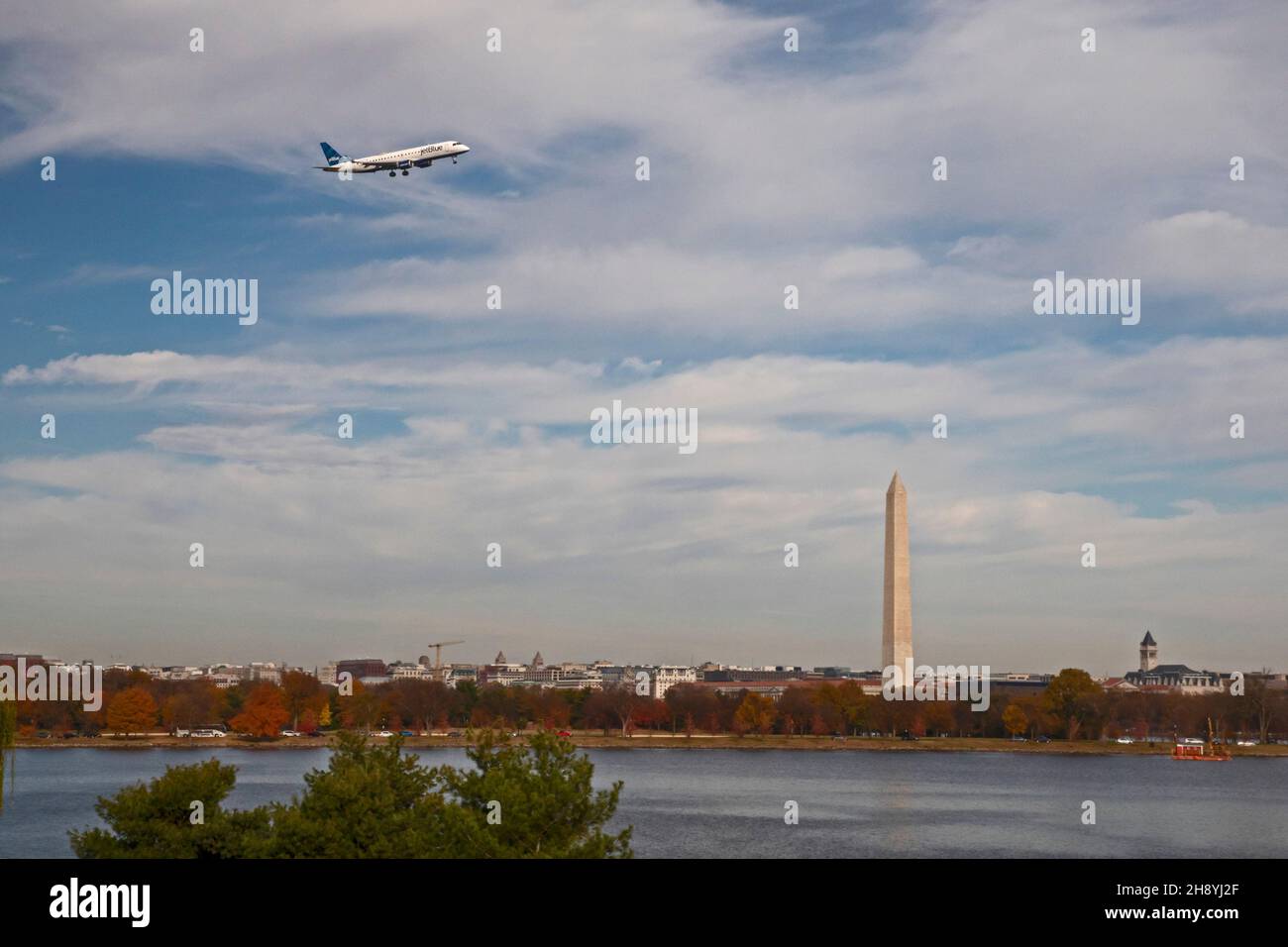 Washington, DC - A Jet Blue airliner on final approach to Ronald Reagan Washington National Airport flies over the Potomac River near the Washington M Stock Photo