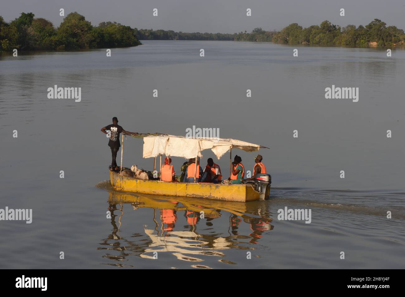 Small passenger ferries carry life-jacketed passengers across the Gambia River to and from Janjanbureh. . Janjanbureh, The Republic of the Gambia. Stock Photo