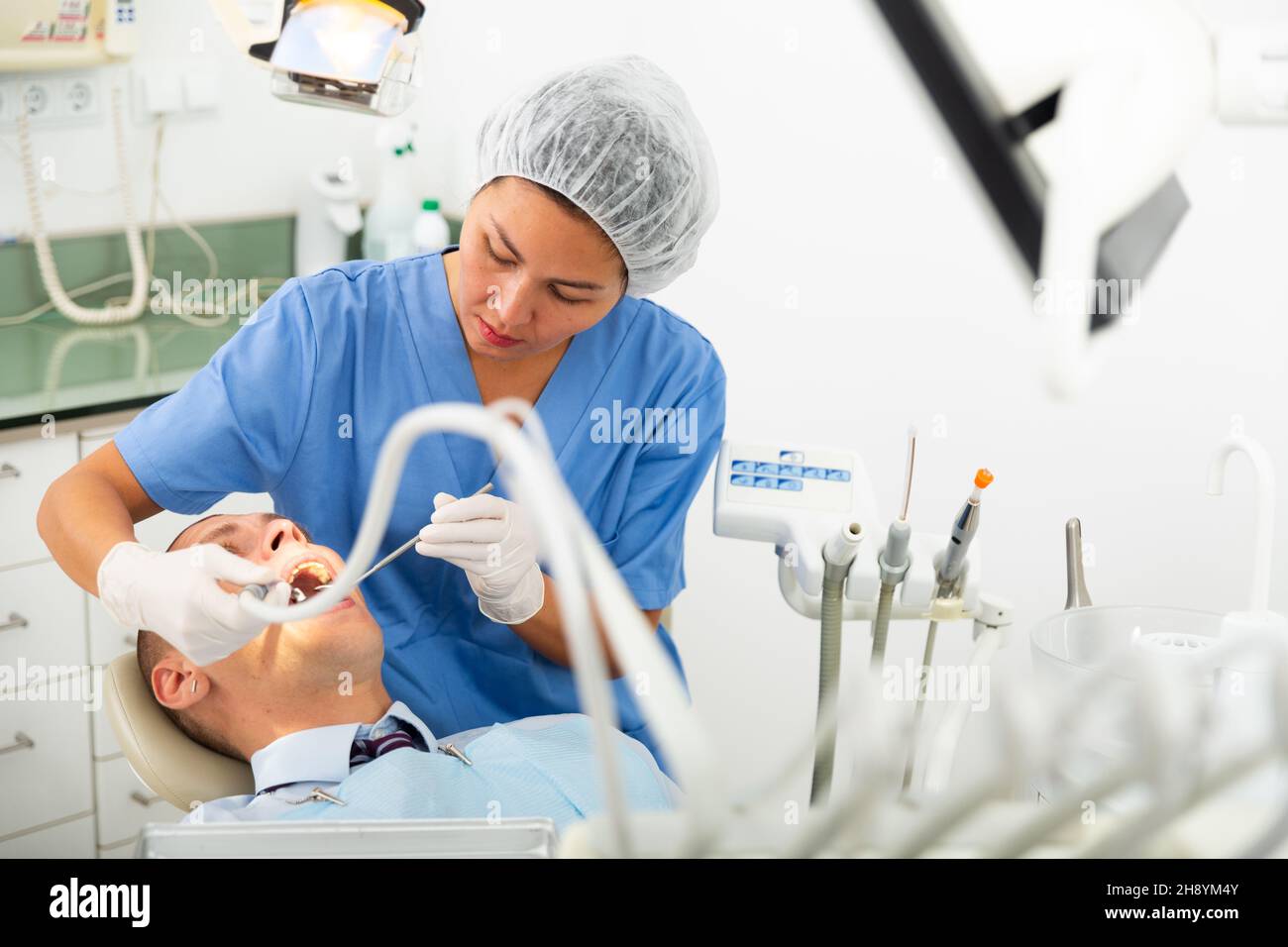 Female dentist drilling tooth to male patient Stock Photo Alamy
