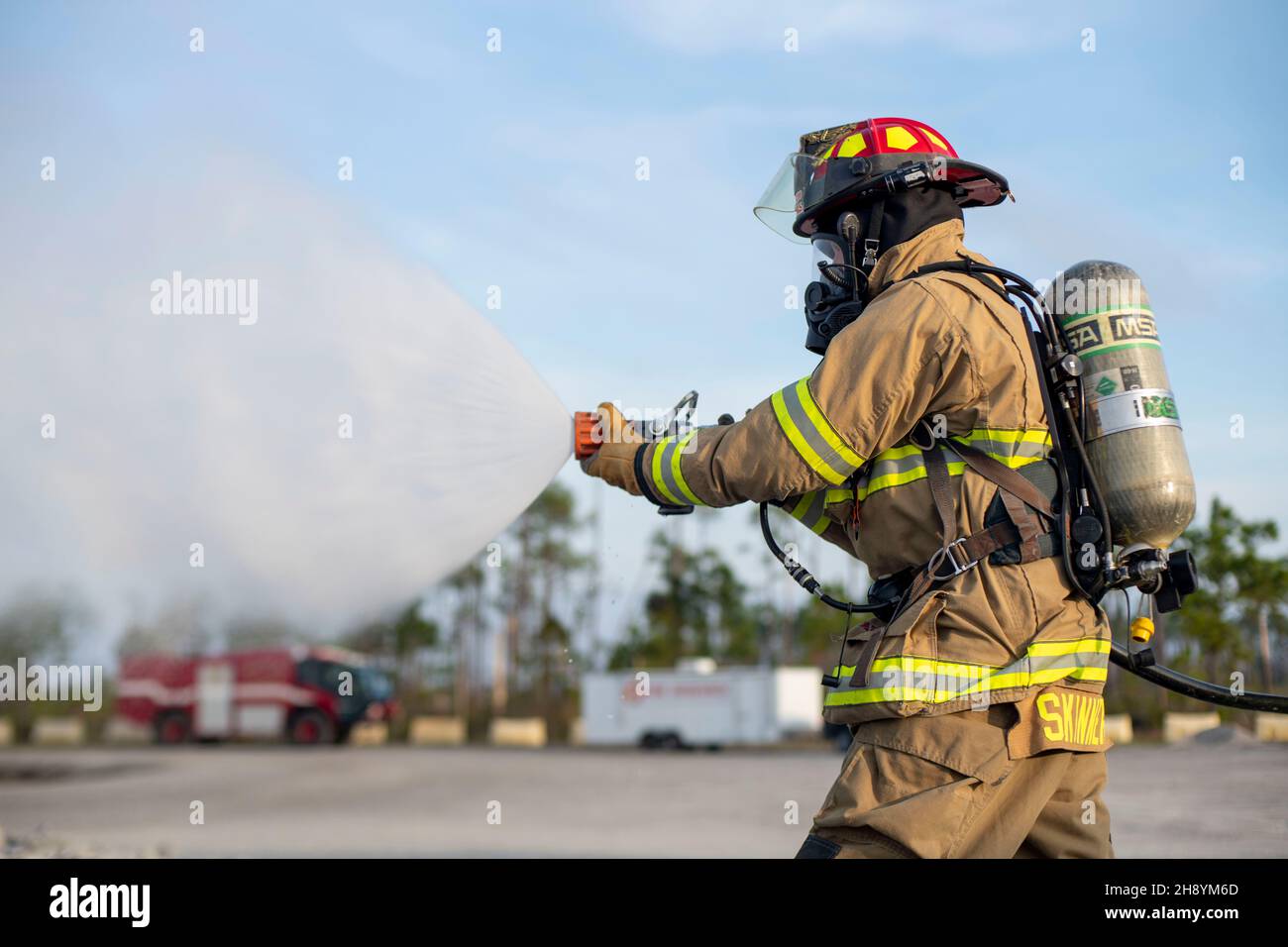 A U.S. Airman operates a fire hose during a Silver Flag fire protection