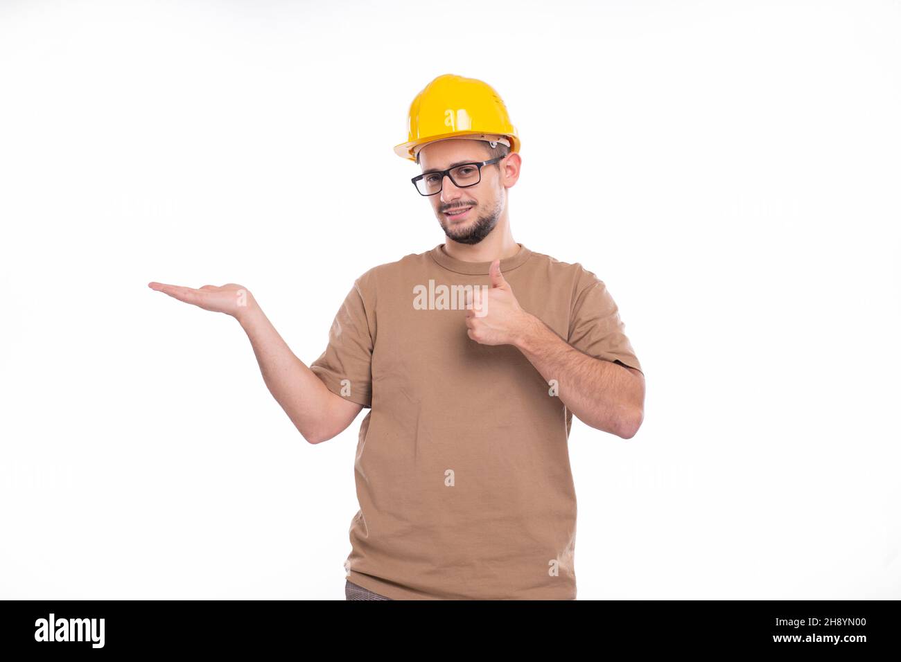 Builder Holding Hand to Side Showing Thumb Up Isolated. Man Construction Worker Sign. Advertisment, Commercial, Business concept Stock Photo