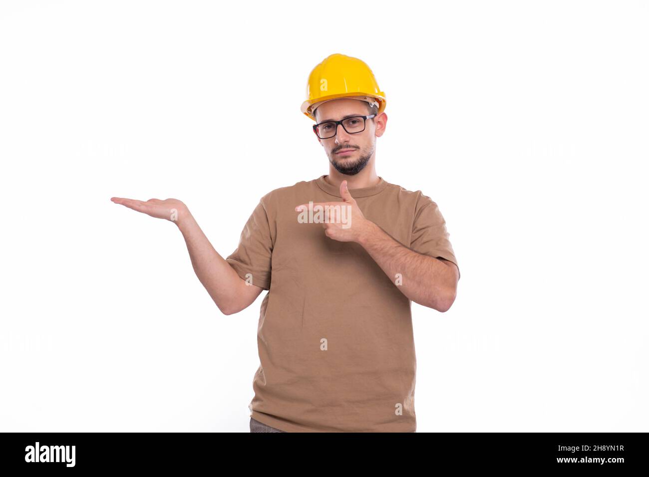 Builder Holding Hand to Side Pointing at It Isolated. Man Construction Worker Sign. Advertisment, Commercial, Business concept Stock Photo