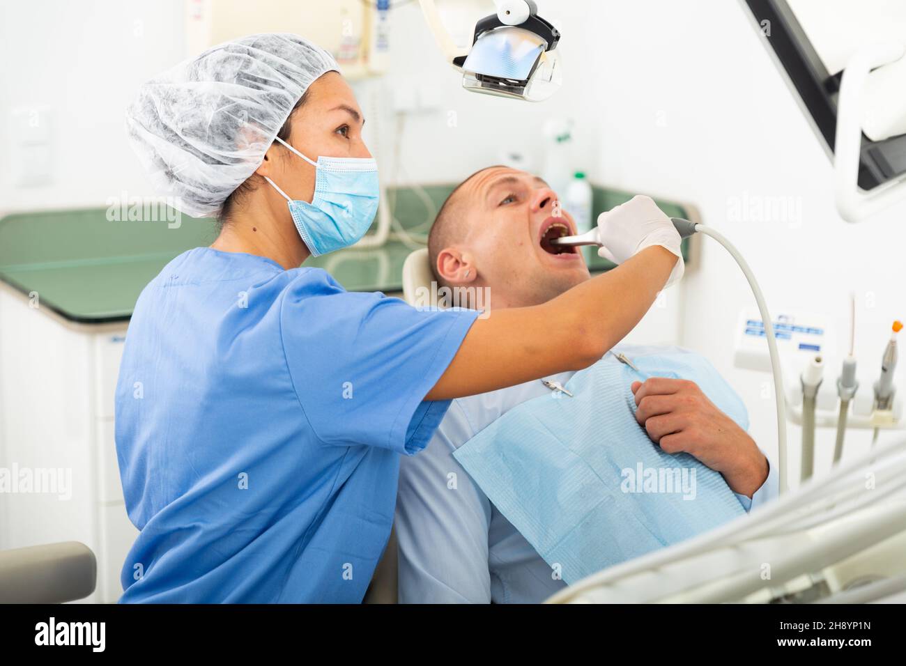 Dentist examines teeth using oral hi-res stock photography and images ...