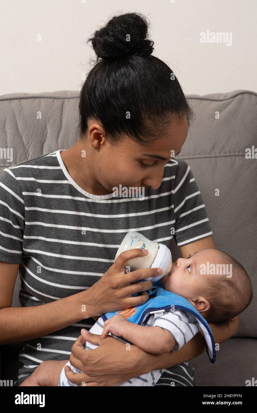 2 month old baby boy (premature) held by mother, fed bottle Stock Photo