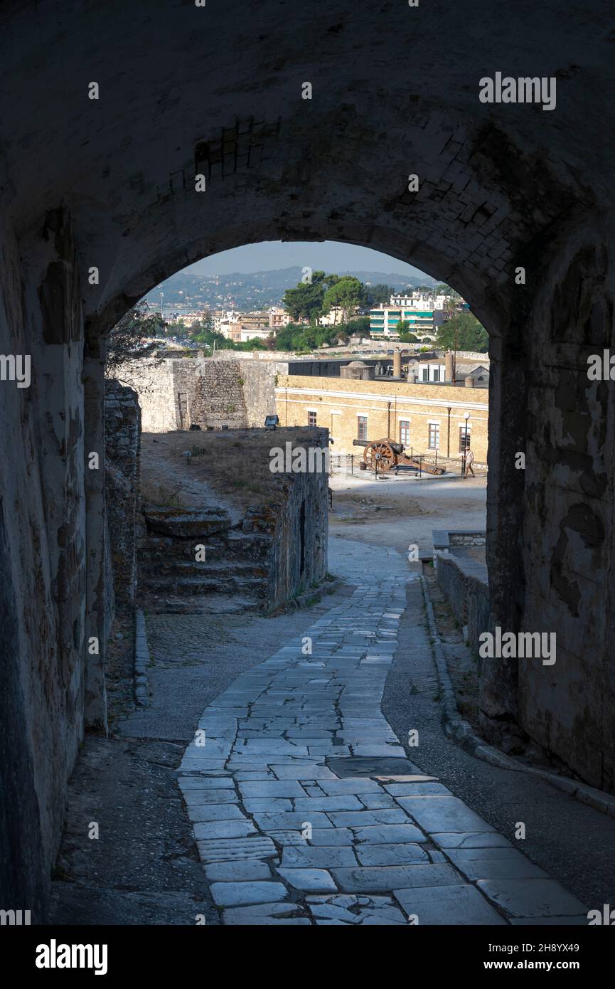 tunnel at the Old Fortress on Corfu leading to the lower level of the fort with a canon and Old Town in the distance Stock Photo
