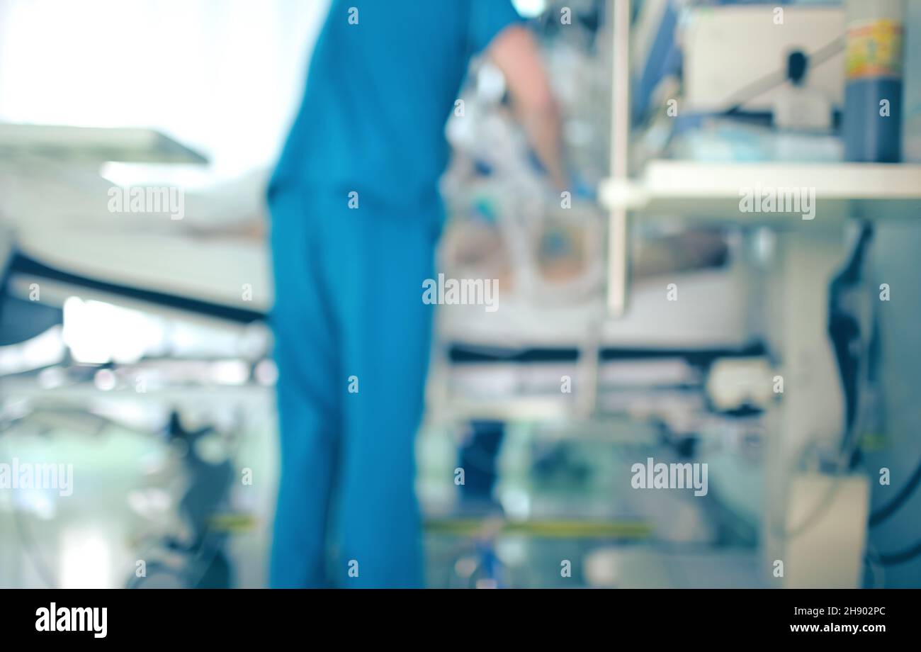 Doctor assists the patient in the intensive care unit, unfocused background. Stock Photo